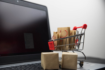 Shopping cart with purchases - packages and boxes with copy space. Online shopping and sale concept.