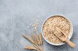 Rolled oats, oat flakes in bowl on concrete background. Top view with copy space. Healthy food, healthy eating, dieting, weight loss and health care concept