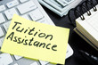 Tuition assistance handwritten on a piece of paper and calculator.