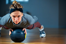 Fit And Muscular Woman With Piercing Eyes Doing Intense Core Workout With Kettlebell In Gym. Female Exercising At Crossfit Gym.