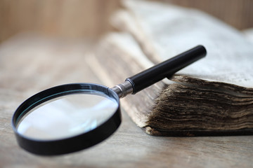 Wall Mural - Old books on a wooden table and magnifier