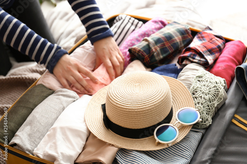 Fotomural Young woman packing suitcase at home. Travel concept