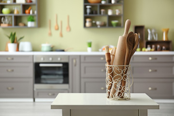 Wooden utensils on white table in modern kitchen