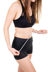 Wall Mural - Crop shot of fitness woman in sport outfit measuring waistline with metric tape