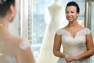 Beautifu bride choosing wedding dress in a wedding salon