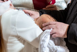Fototapeta Pomosty - A fragment of a photograph of a little boy preparing for a baptismal ceremony, legs on a white blankets, baptism