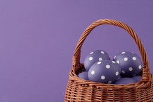 Wicker Basket With Purple Painted Easter Eggs With Dots