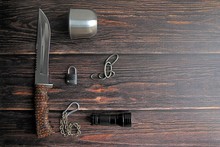 Hunting Knife, Lantern, Carbines, Mug On A Brown Wooden Background