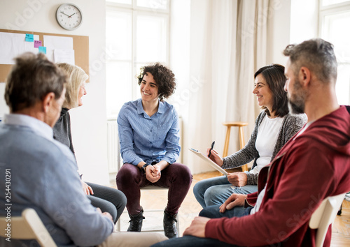 Cuadros en Lienzo Men and women sitting in a circle during group therapy, talking.