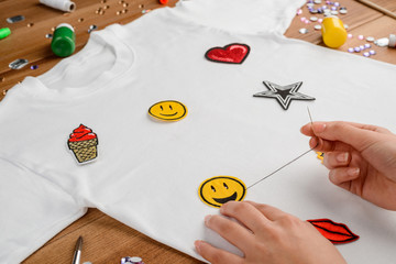 girl sewing a patch to t-shirt