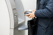 © Mihail - persons hand hold a wallet with cash and withdraw some money in atm