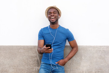 Wall Mural - happy african american man listening to music with cellphone and earphones