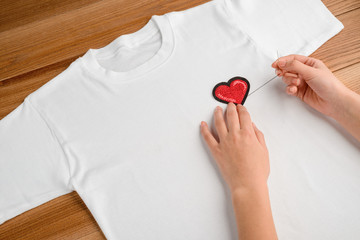 girl applying embroidered heart patch