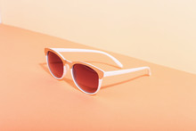 Sunglasses Lie On A Colored Background Casting A Harsh Shadow, Concept Art Of Summer And Relaxation, Minimalism.