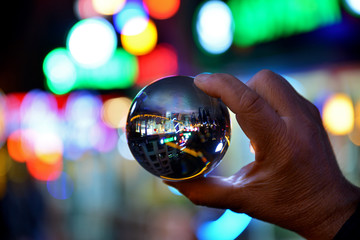 Wall Mural - hand holding lens ball on bokeh background