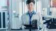 © Gorodenkoff - On High-Tech Factory Asian Worker Holds Batch with Electronic Printed Circuit Board Assembled with use of Surface Mount Technology on Pick and Place Machinery.