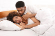 © Prostock-studio - Unhappy woman lying in bed, her boyfriend apologizing