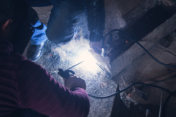 Wall Mural - Welder performs welding work on metal in protective mask.