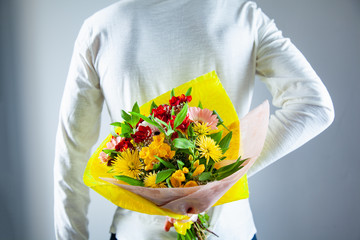 Wall Mural - man hand flowers bouquet in back