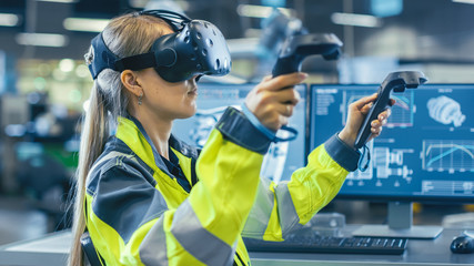 Wall Mural - Female Industrial Engineer Wearing Virtual Reality Headset and Holding Controllers, She Uses VR technology for Industrial Design, Development and Prototyping in CAD Software.