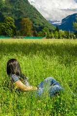 Wall Mural - Girl lies in the grass in city Interlaken, Switzerland