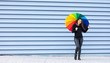 Young girl in black clothes and colorful umbrella with cheerful and smiling