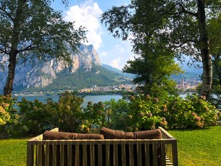 indoor brown wooden bench with ocean and mountain background