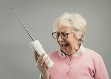 Frustrated Senior Woman Using An Old Telephone