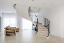 Spiral Staircase In Bright Interior With White Brick Wall In Elite Expensive Apartment