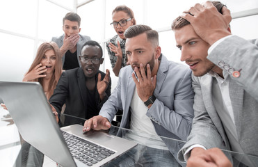 Frustrated females and males sales managers working in showroom, looking at laptop monitor