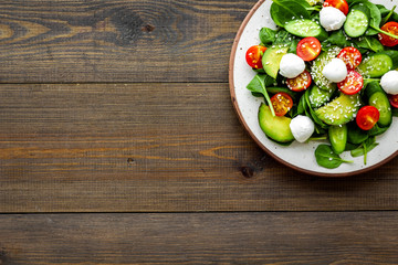 Wall Mural - Vegetarian meal. Fresh vegetable salad on dark wooden background top view copy space