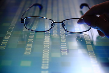 hand reaching for glasses on digital led displaying multiple layers of binary code computer data matrix. big data analytics and digital language concepts. random white code on blue grid background