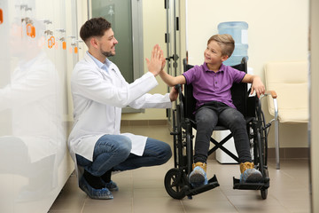 Wall Mural - Doctor and little child in wheelchair at hospital