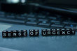 Sense of urgency text wooden blocks in laptop background. Business and technology concept