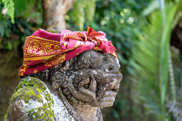 Wall Mural - Traditional stone statue depicting demon, god and Balinese mythological deities in Ubud, island Bali, Indonesia , closeup