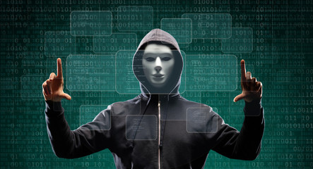 Computer hacker in mask and hoodie over abstract binary background. Obscured dark face. Data thief, internet fraud, darknet and cyber security.