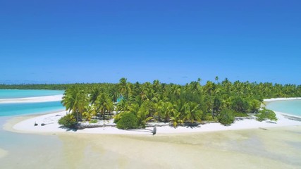 Wall Mural - DRONE: Flying away from empty white sand beach of a remote paradise island in the middle of the turquoise colored sea. Picturesque shot from above of exotic island and tourist boat anchored nearby.