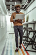 © Viacheslav Yakobchuk - Dark-skinned focused man with funky hairstyle moving around with laptop