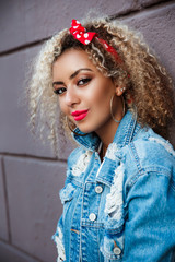 Wall Mural - Close up portrait of positive curly afro american woman in city