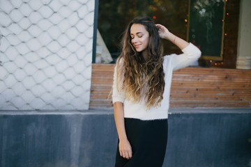 Young beautiful happy woman with long curly hair having free time outdoors