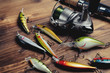 Fishing tackle - fishing spinning, hooks and lures on wooden background