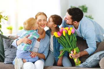 happy mother's day! father and children congratulate mother on holiday