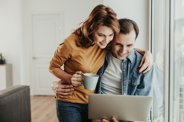 Male and female looking in laptop with interest