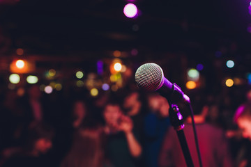 Microphone with blurred colorful bright light in dark night background, soft focus image for business technology communication concepts.