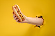 Hand taking a hot dog