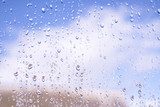 Fototapeta Tęcza - Beautiful raindrops on the window glass. Spring summer weather with warm rain. Stock photo