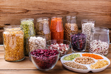 Wall Mural - Glass jars with various legumes and grains-beans, rice, lentils, bulgur and  grains on concrete background