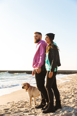 Lovely young couple playing with their dog