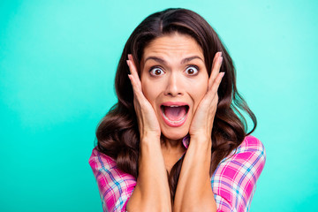 Close up photo amazing yelling loud she her curly wavy lady hold cheekbones eye full of fear oh no wearing casual plaid checkered pink shirt outfit isolated teal green bright vivid vibrant background