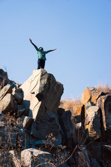 Wall Mural - African Man traveler with film camera  standing on top of a mountain and looking at fly seagull